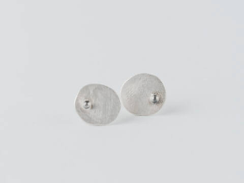 boucles d'oreilles puces en argent composées de petites pastilles ovales martelées ornées d'une petite bille.