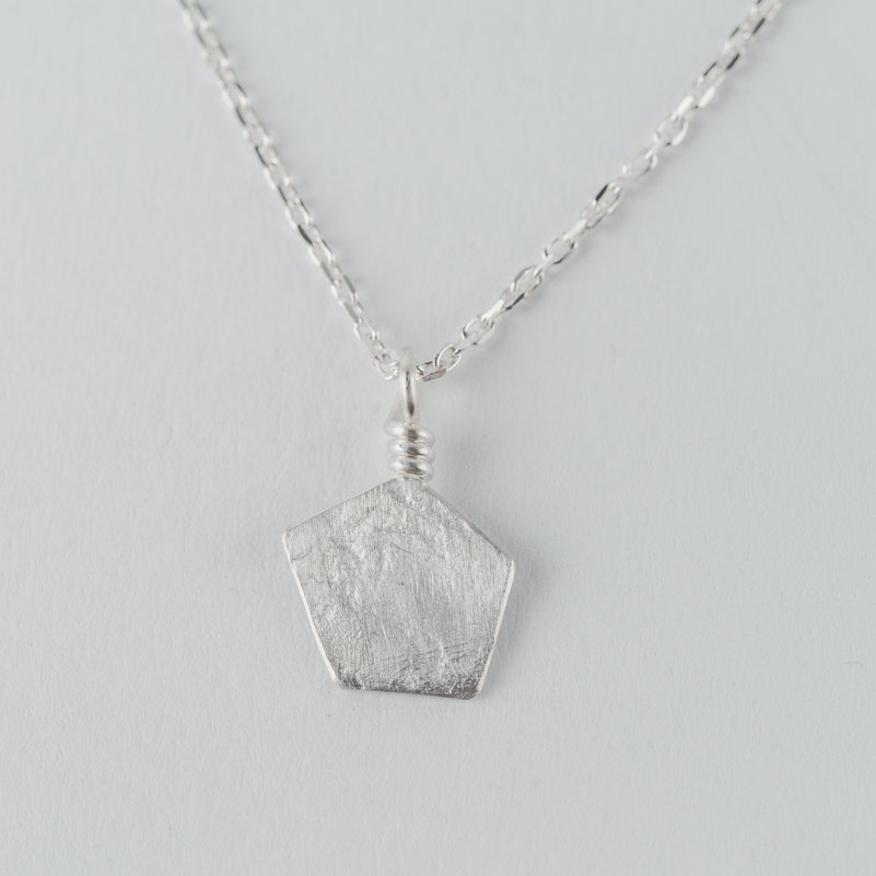 Collier en argent composé d’un pendentif de forme géométrique, effet de matière “froissé”, monté sur chaîne
