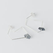boucles d'oreilles pendantes composées d'une forme géométrique en fil sur laquelle circule une pastille de forme pentagonale en argent noirci et texture froissée.