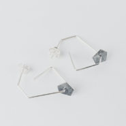 boucles d'oreilles pendantes composées d'une forme géométrique en fil sur laquelle circule une pastille de forme pentagonale en argent noirci et texture froissée.